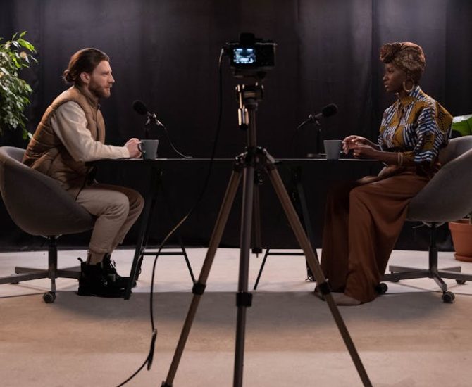 Dynamic podcast session featuring two hosts with studio lighting and recording equipment.